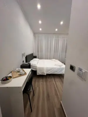 a small room with a bed and a desk and a room with a desk at Suite 98 in Rome