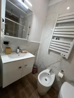 a white bathroom with a sink and a toilet at Suite 98 in Rome