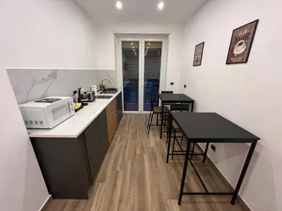 a kitchen with a microwave and a table with chairs at Suite 98 in Rome