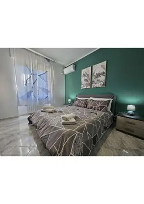 a bedroom with a large bed with a green wall at Erika's Apartment in Rome