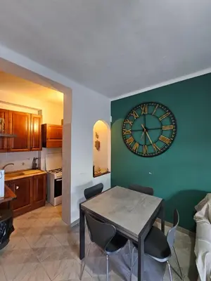 a kitchen with a table and a clock on the wall at Erika's Apartment in Rome