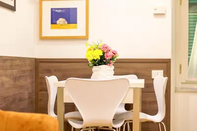 a white table with a vase of flowers on it at Coppedè Lovely Apartment in Rome