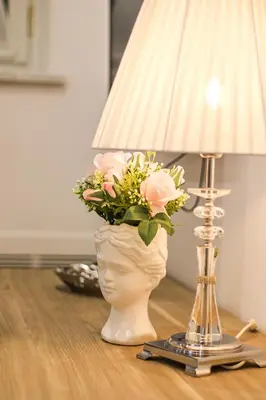 a vase with flowers in it next to a lamp at Coppedè Lovely Apartment in Rome