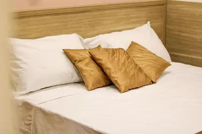 a bed with white pillows and gold pillows at Coppedè Lovely Apartment in Rome