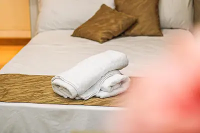 a rolled up white towel on a bed at Coppedè Lovely Apartment in Rome