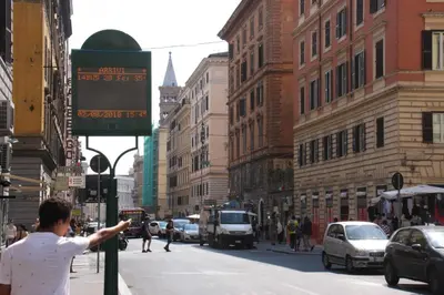 a man pointing at a street sign on a busy city street at Beautiful Colosseum Roma in Rome