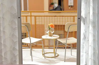a table and chairs on a balcony with a vase of flowers at Golden Apartment in Rome