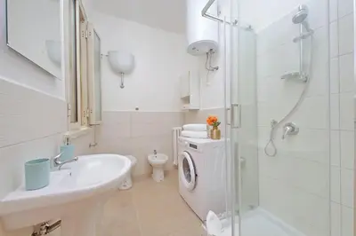a bathroom with a sink and a washing machine at Golden Apartment in Rome