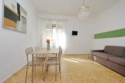a living room with a table and chairs and a couch at Golden Apartment in Rome