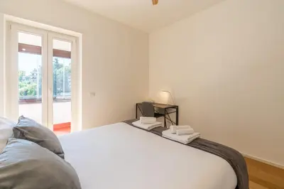 a white bedroom with a bed and a window at Apartment Valle Aurelia Metro in Rome