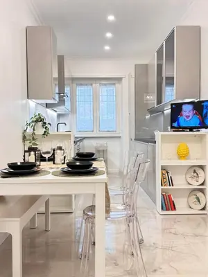 a white kitchen with a dining table and chairs at Casa Giulia in Rome