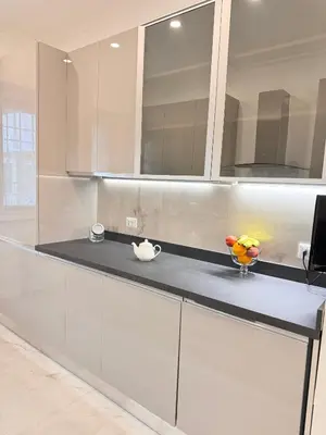 a kitchen with white cabinets and a vase of fruit on a counter at Casa Giulia in Rome