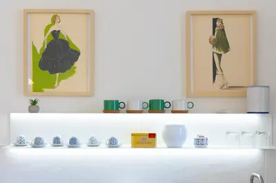 a white shelf with two framed pictures on top of it at San Lorenzo Style Apartment in Rome