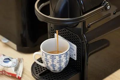 a cup of coffee is being brewed in a microwave at San Lorenzo Style Apartment in Rome