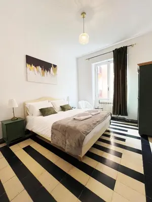 a bedroom with a large bed and a checkered floor at Key apartments Vatican Flat in Rome