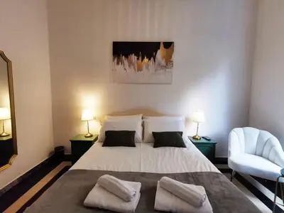 a bedroom with a bed with two pillows and a chair at Key apartments Vatican Flat in Rome