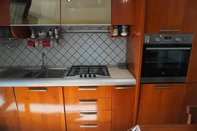 a kitchen with wooden cabinets and a stove and a sink at Stazione Trastevere Apartment in Rome