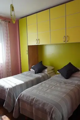 two beds in a room with yellow and green walls at Stazione Trastevere Apartment in Rome