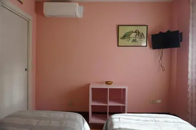 a bedroom with pink walls and a bed and a table at Stazione Trastevere Apartment in Rome