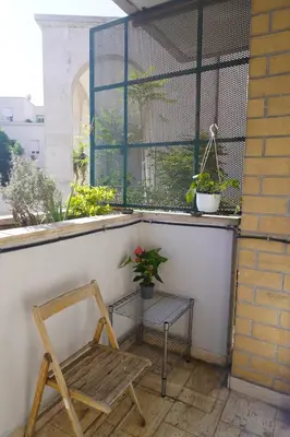a chair and a table on a balcony with plants at Stazione Trastevere Apartment in Rome