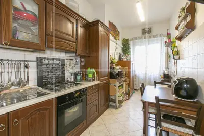 a kitchen with wooden cabinets and a stove top oven at Trastevere in Station in Rome