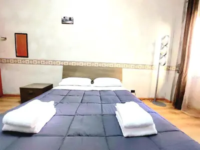 a bedroom with a large blue bed with white pillows at Trastevere in Station in Rome