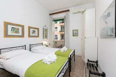 two beds in a room with white walls at Clodia 5 by Rental in Rome in Rome