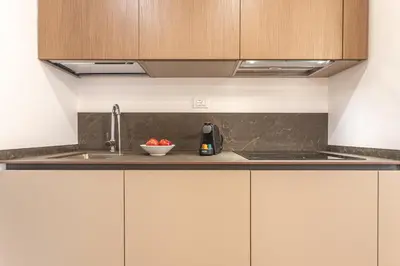 a kitchen with a sink and a bowl of fruit at Vatican Modern Apartment 5 min Metro A - Terrestre in Rome
