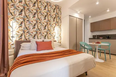 a bedroom with a bed and a table and a kitchen at Vatican Modern Apartment 5 min Metro A - Terrestre in Rome