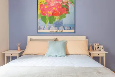 a bedroom with a bed with a painting on the wall at Roma is amoR in Rome