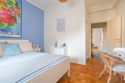 a bedroom with a large bed and a chair at Roma is amoR in Rome