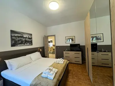 a bedroom with a large white bed and a television at Laura's house in Alberone in Rome