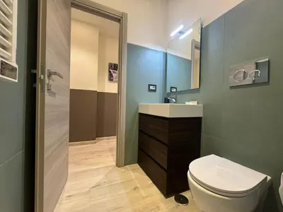 a bathroom with a toilet and a sink and a mirror at Laura's house in Alberone in Rome