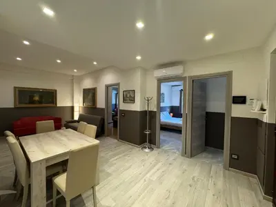 a dining room with a table and a living room at Laura's house in Alberone in Rome
