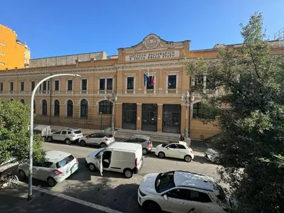 a large building with cars parked in a parking lot at Laura's house in Alberone in Rome