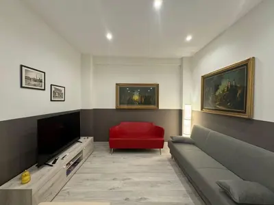 a living room with a couch and a red chair at Laura's house in Alberone in Rome
