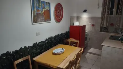 a kitchen with a table and chairs and a red refrigerator at Saint Peter Apartment in Rome