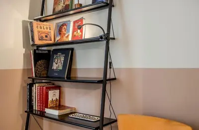 a black book shelf with books and a chair at Atelier Gianicolo Suite in Rome