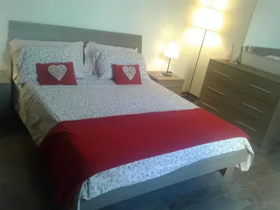 a bedroom with a bed with two red pillows at Testaccio Roma Style Apartment in Rome