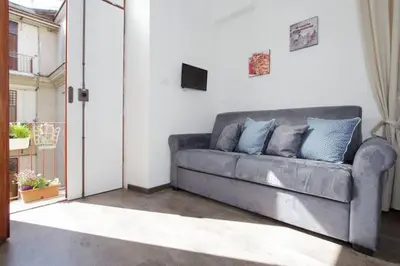 a gray couch in a living room with a television at Testaccio Roma Style Apartment in Rome