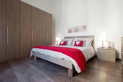 a bedroom with a large bed with red pillows at Testaccio Roma Style Apartment in Rome