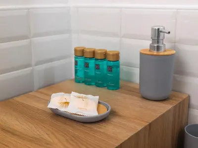 a counter with a soap dispenser and bottles of water at 2BDR Testaccio Sweet Home in Rome