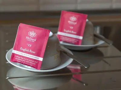two pink pamphlets sitting on a plate on a table at 2BDR Testaccio Sweet Home in Rome