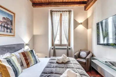 a bedroom with a bed and a chair and a window at Casa Navona Apartments in Rome