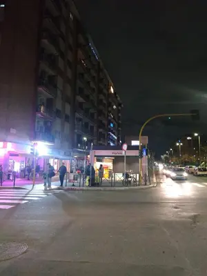 a group of people walking down a street with lights at DàLù alPigneto in Rome