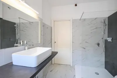 a bathroom with a white sink and a shower at La Casa Sui Musei Vaticani in Rome
