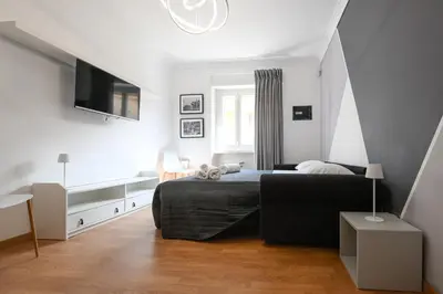 a bedroom with a bed and a tv on the wall at La Casa Sui Musei Vaticani in Rome