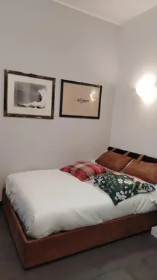 a bed in a bedroom with two pictures on the wall at B&B Garbatella-Sotto l'arco del Lotto 28 in Rome