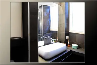 a bathroom with a white sink and a mirror at B&B Garbatella-Sotto l'arco del Lotto 28 in Rome