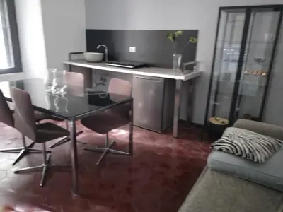 a dining table and chairs in a living room at Hostapartment SUITE UP in Rome